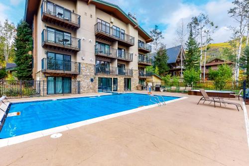 a swimming pool in front of a apartment building at Scandinavian Lodge 203 in Steamboat Springs