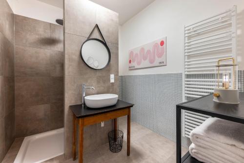 a bathroom with a sink and a mirror and a tub at Suiten im Alten Berghotel Johanna in Niedersalwey