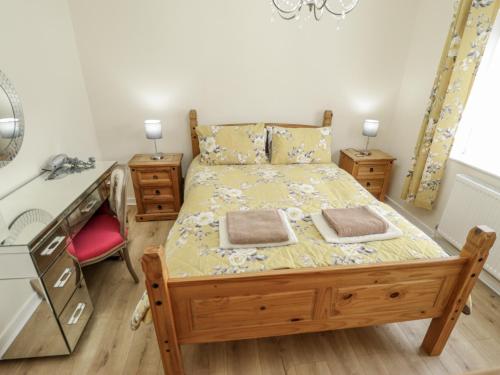 Schlafzimmer mit einem Bett, einem Schreibtisch und einem Waschbecken in der Unterkunft 5 Links Court in Skegness