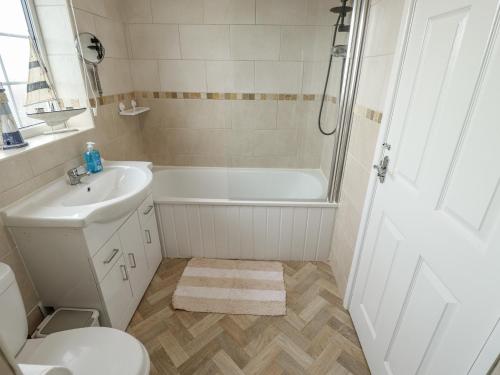 ein Badezimmer mit Badewanne, Waschbecken und Toilette in der Unterkunft 5 Links Court in Skegness