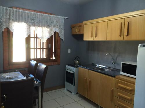 une cuisine avec un évier et une cuisinière four supérieur dans l'établissement Residencial Quatro Estações, à Canela