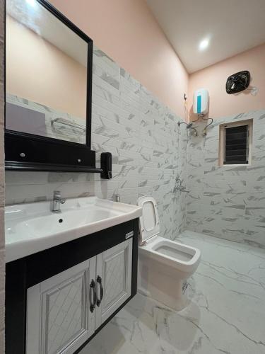 a bathroom with a white sink and a toilet at Rooftop Grove Zenith in Guwahati