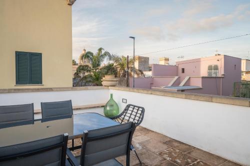 a patio with a table and chairs on a balcony at Amazing Apartment Alla Corte with pool and sauna in Taurisano