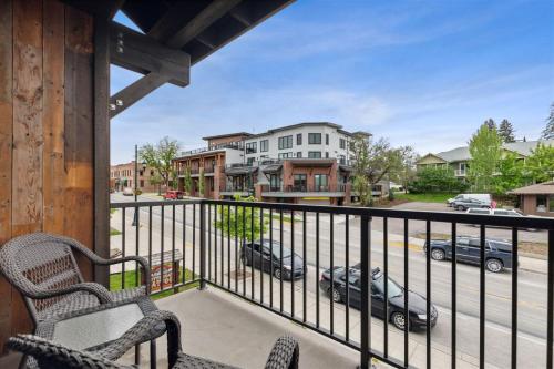 a balcony with two chairs and a view of a street at 2nd Street Lofts 209 in Whitefish