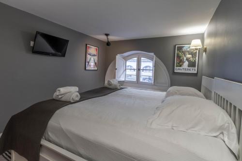a bedroom with a large white bed with a window at Le Gramont, T3 en hypercentre de Pau - avec clim in Pau