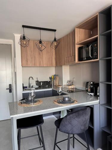 eine Küche mit Theke und zwei Barhockern in der Unterkunft Estadio Nacional Ñuñoa in Santiago