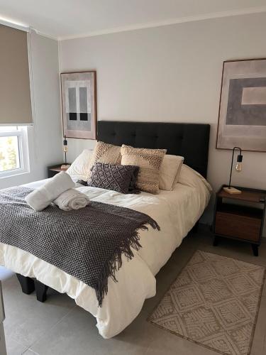 ein Schlafzimmer mit einem großen Bett mit schwarzem Kopfteil in der Unterkunft Estadio Nacional Ñuñoa in Santiago