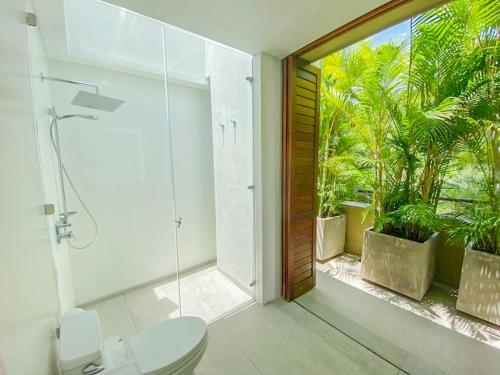 a bathroom with a shower and a toilet and plants at Penthouse de Lujo-Mesa de yeguas Country Club Golf lago Naturaleza in Anapoima