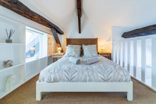 a bedroom with a white bed and a window at Le Duplex du Château – Fontainebleau Centre in Fontainebleau