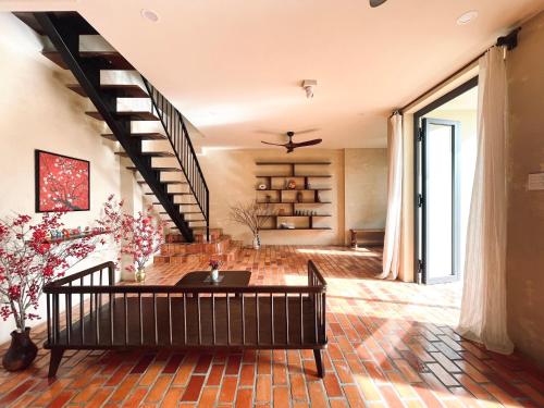 a living room with a staircase and a table at Biển house in Ấp Khánh Phước (1)