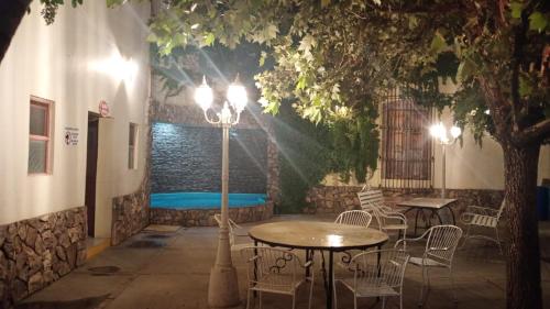 een terras met een tafel en stoelen en een zwembad bij Hotel Colonial 
