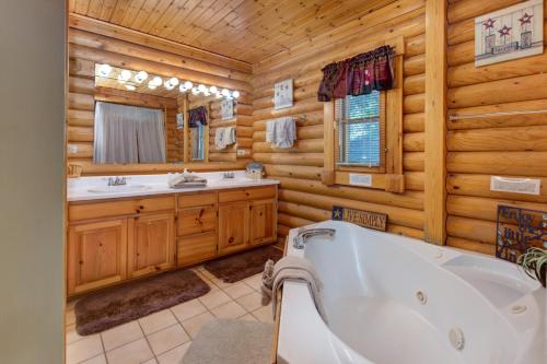 a log cabin bathroom with a tub and a sink at Unforgettable Dreams By Avada Properties in Catlettsburg