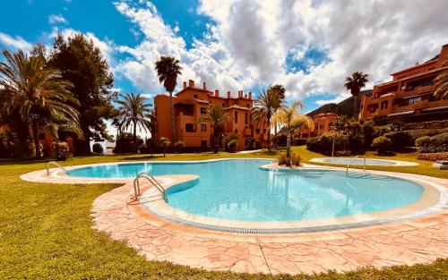 une grande piscine dans une cour avec des bâtiments dans l'établissement Cosy & Moderne appartement vue mer, à Finestrat