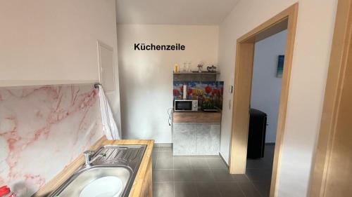 a bathroom with a sink and a counter at Kim Homestay A Zimmer A2 in Sömmerda