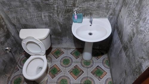 a bathroom with a toilet and a sink at Hometown Pai Boutique Bungalow in Pai