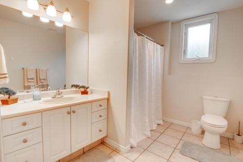 a bathroom with a toilet and a sink and a mirror at Cozy Lakeview Retreat in Kettle Valley in Kelowna