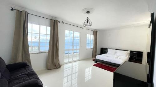 - un salon blanc avec un lit et un canapé dans l'établissement Casa Borboleta, à Arco da Calheta