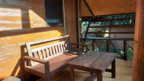 a wooden bench sitting on a porch next to a window at Hometown Pai Boutique Bungalow in Pai