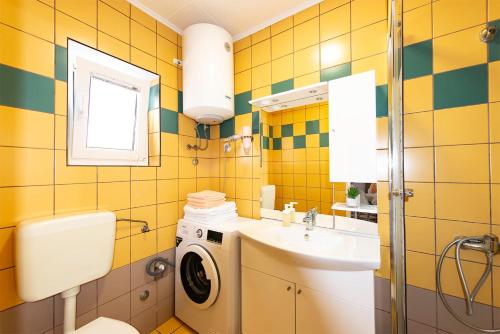 a bathroom with a washing machine and a sink at Apartments Lili in Pag