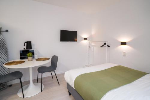 een hotelkamer met een bed, een tafel en een bed bij Cinquantenaire 1 in Brussel