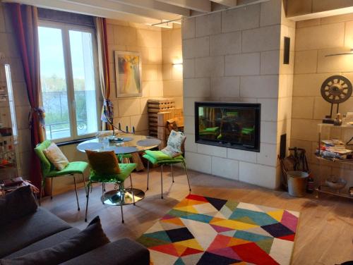 a living room with a table and chairs and a fireplace at Naturellement Loire ! in Saint-Martin-de-la-Place