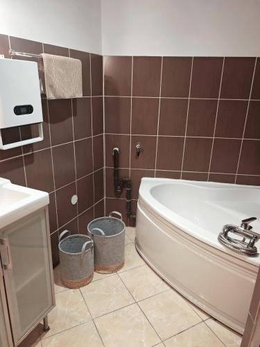 a bathroom with a tub and two trash cans at Studio La grotte Bohème in Lourdes