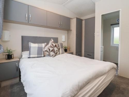 a bedroom with a large white bed and a window at Meadows Park 4 in Hull