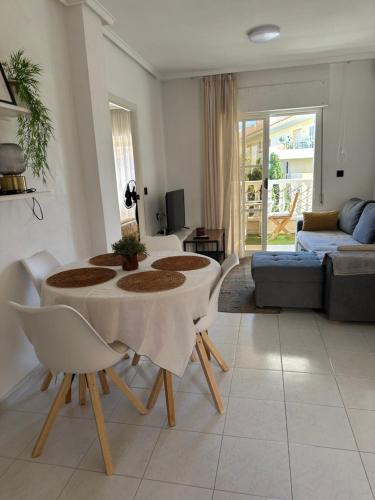Una sala de estar con una mesa y sillas y un sofá. en PARQUE AROMATICO CON DOS PISCINAS, en Torrevieja