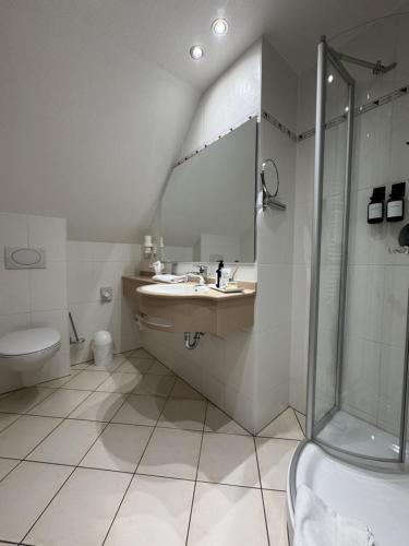 a bathroom with a sink and a shower at Apartmenthaus Blauer Wolf by ROom for LIving Gunzenhausen in Gunzenhausen