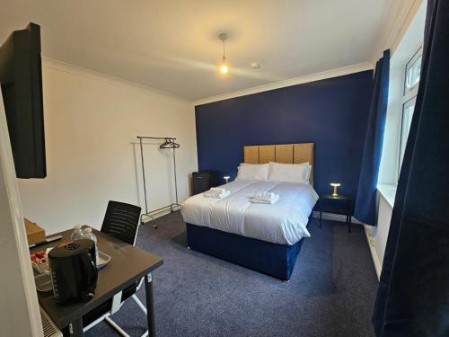 a hotel room with a bed with a blue wall at Airport Lodge in Sheldon