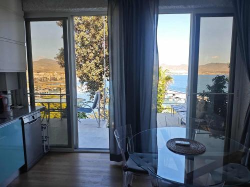 a kitchen with a glass table and a view of the ocean at The sea-cave house in Puerto de Mazarrón