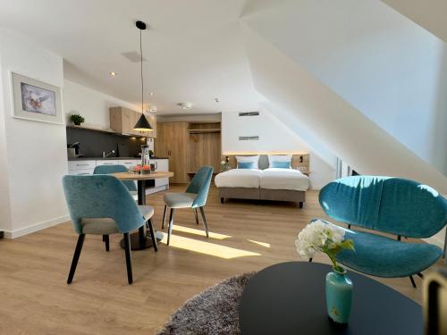 a living room with blue chairs and a bedroom at Apartmenthaus Blauer Wolf by ROom for LIving Gunzenhausen in Gunzenhausen