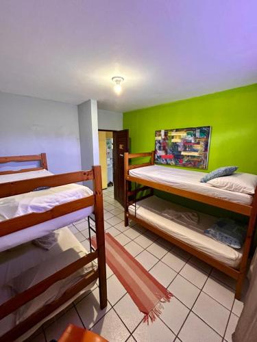 a room with two bunk beds and a green wall at Parnaíba Hostel in Parnaíba