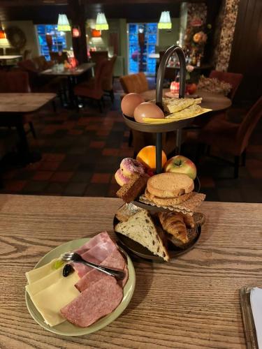 ein Tisch mit einem Teller mit verschiedenen Sandwichsorten in der Unterkunft Hotel Boerderij Restaurant De Gloepe in Diffelen