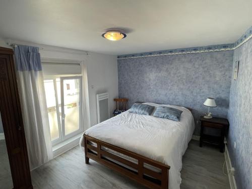 a bedroom with a large bed and a window at Ma Toquade in Quiberville