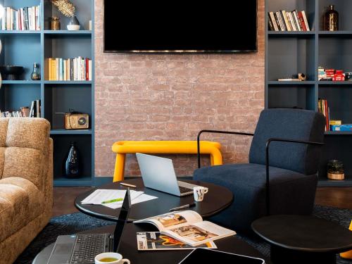 a living room with a desk with a laptop and a chair at Ibis Styles Lyon Villeurbanne Parc de la Tête d'Or in Villeurbanne