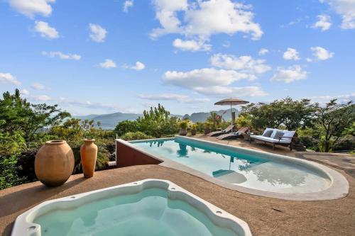 a large swimming pool sitting next to a villa at Private 5-Bedroom Compound with Pool Tepoztlán Retreat in Tepoztlán