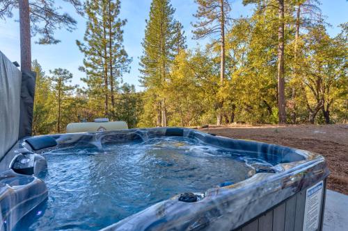 un jacuzzi en el bosque en A Modern Hideaway - with hot tub, game room, and more, en Oakhurst