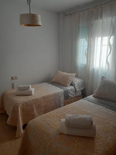 a room with two beds with towels on them at APARTAMENTO EL TIMON in Carboneras