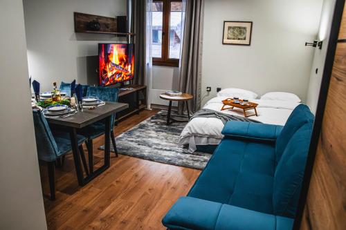a bedroom with a blue couch and a table and a bed at VujSki - Gondola Apartman in Brzeće