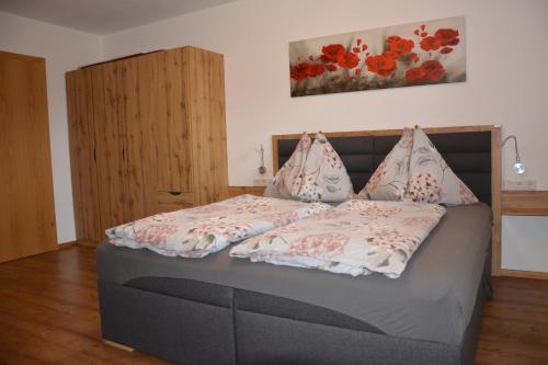 Un dormitorio con una cama grande con suelo de madera. en Appartement Wieshof, en Neukirchen am Großvenediger