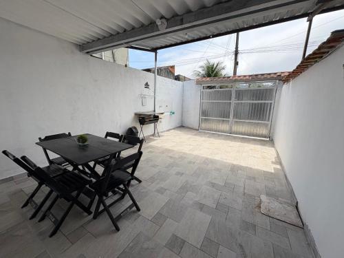 ein Esszimmer mit einem Tisch und Stühlen auf einer Terrasse in der Unterkunft Casa em Angra dos Reis, no parque mambucaba in Angra dos Reis