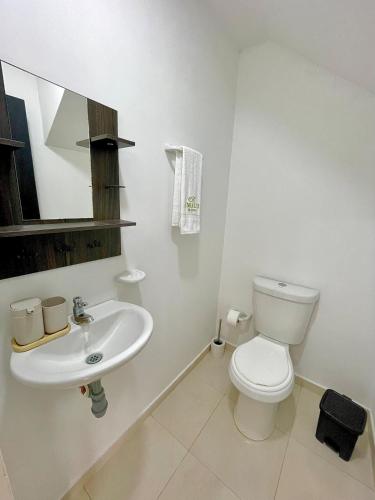 a white bathroom with a toilet and a sink at Amalfi Home 2Hab AA in Montería