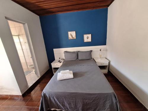 Un dormitorio con una cama con una pared azul. en Pousada Marina bonita Rasa, en Búzios