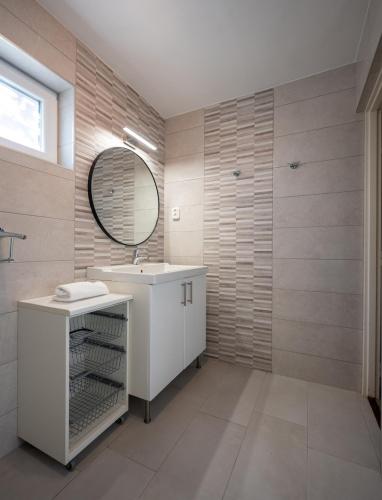 a bathroom with a sink and a mirror at Arborétum Nyaraló Szarvas - Kültéri jakuzzival in Szarvas