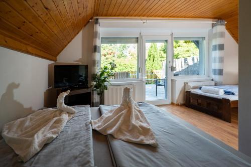 Un dormitorio con una cama con dos vestidos. en Arborétum Nyaraló Szarvas - Kültéri jakuzzival, en Szarvas