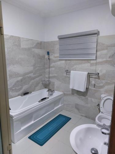 ein Badezimmer mit Badewanne, Toilette und Waschbecken in der Unterkunft Apartments in Lekki in Lekki