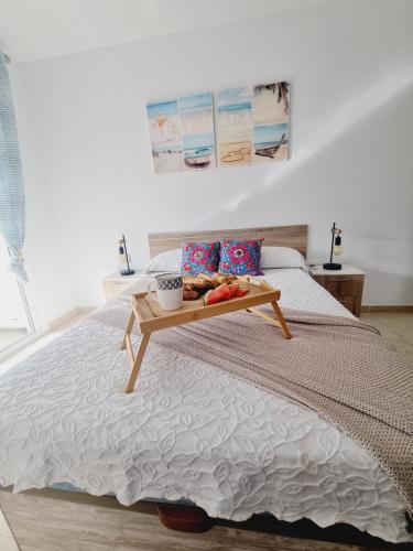 a bed with a tray of food on top of it at Sal Marina in Puertito de Güímar