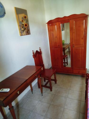 a dining room with a wooden table and a chair at Le petit couin des voyageurs in Bouillante