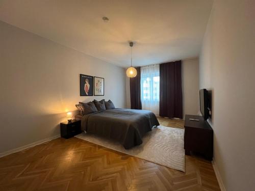 a bedroom with a bed and a flat screen tv at City apartment with balcony in Norrköping
